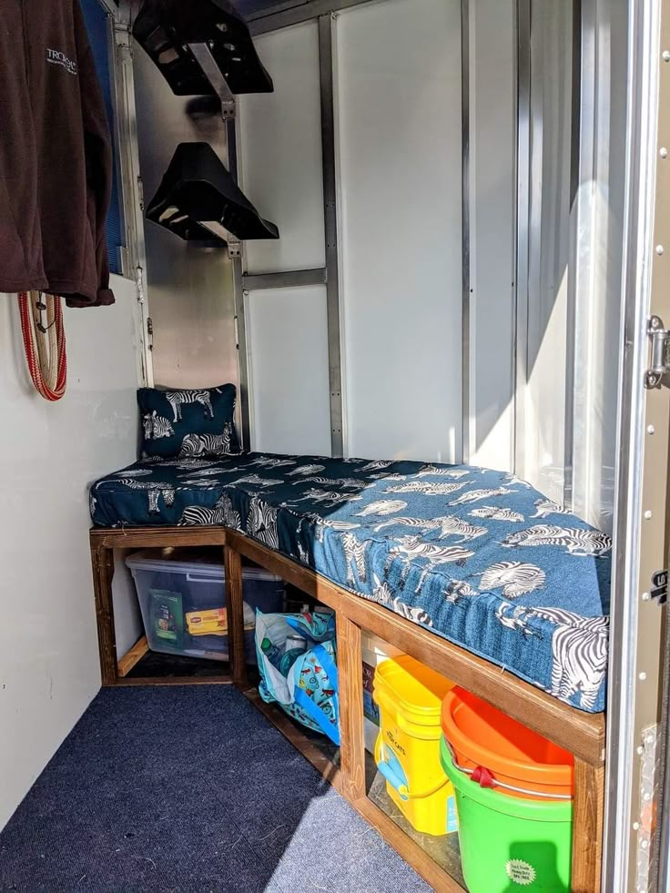 the inside of a camper with two bunk beds and storage bins for toys