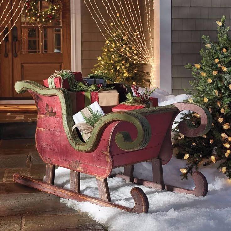 a sleigh filled with presents sitting in front of a christmas tree