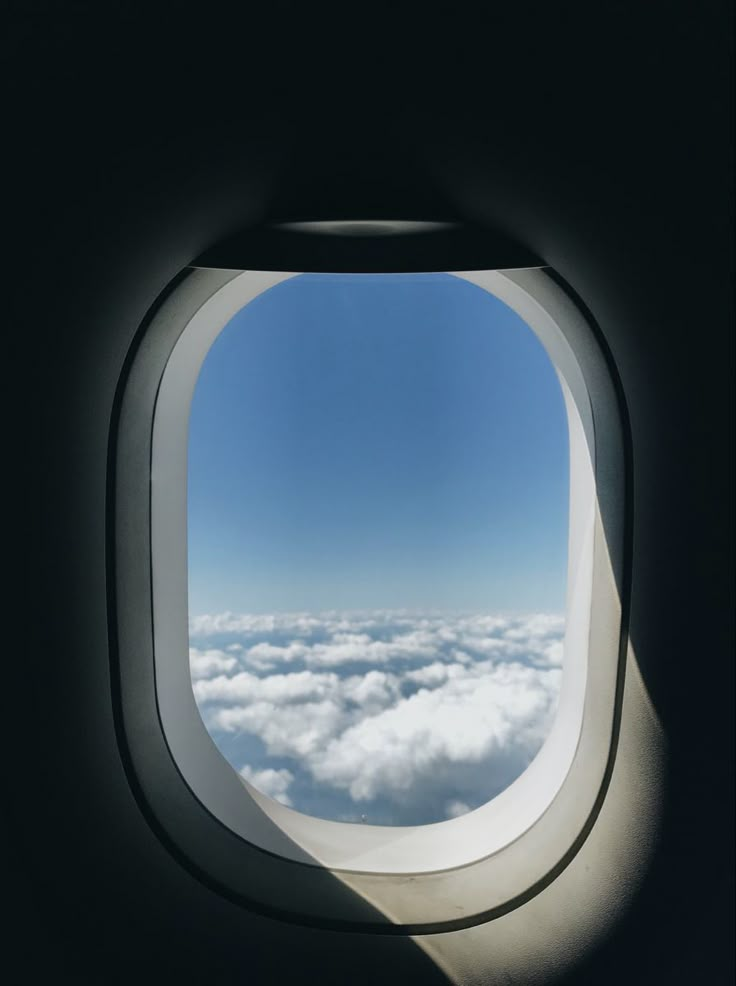 an airplane window looking out at the clouds