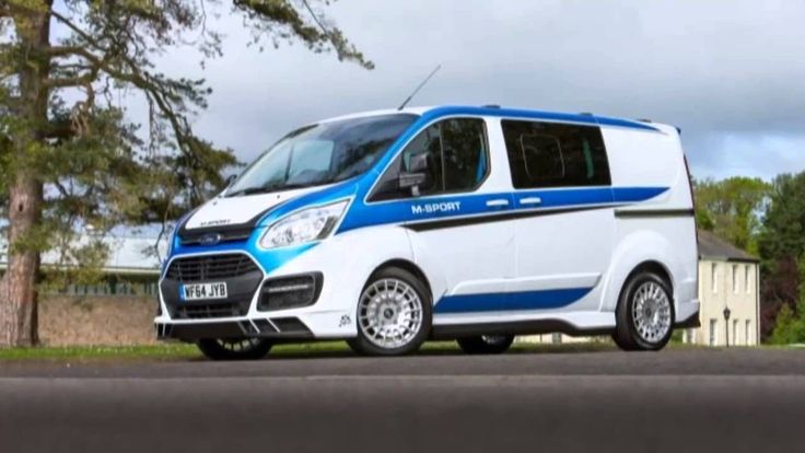 a blue and white van is parked on the side of the road in front of some trees