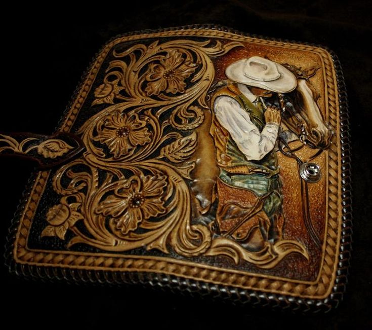 an intricately decorated leather case with a cowboy on it