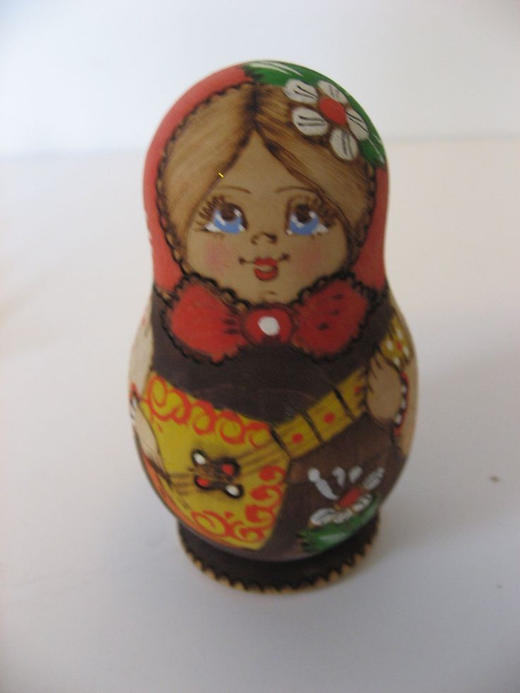 a small wooden doll sitting on top of a table