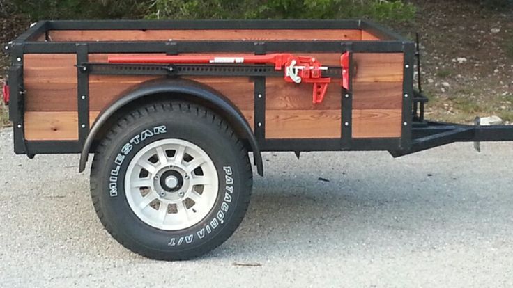 the trailer is made from wood and has two wheels on each side, which are attached to