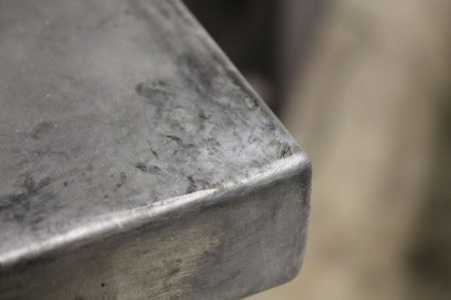 a close up view of a metal object with some dirt on the ground behind it