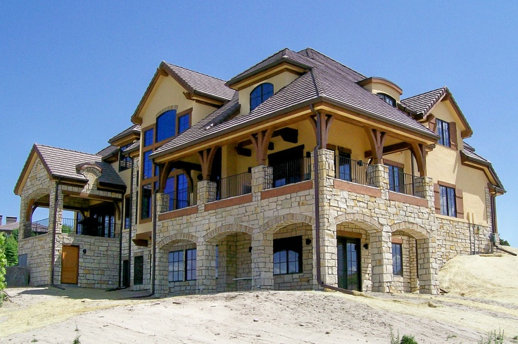 a large house with lots of windows on the front and side of it's roof