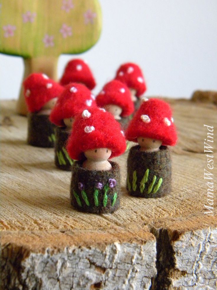 small red mushrooms sitting on top of a piece of wood