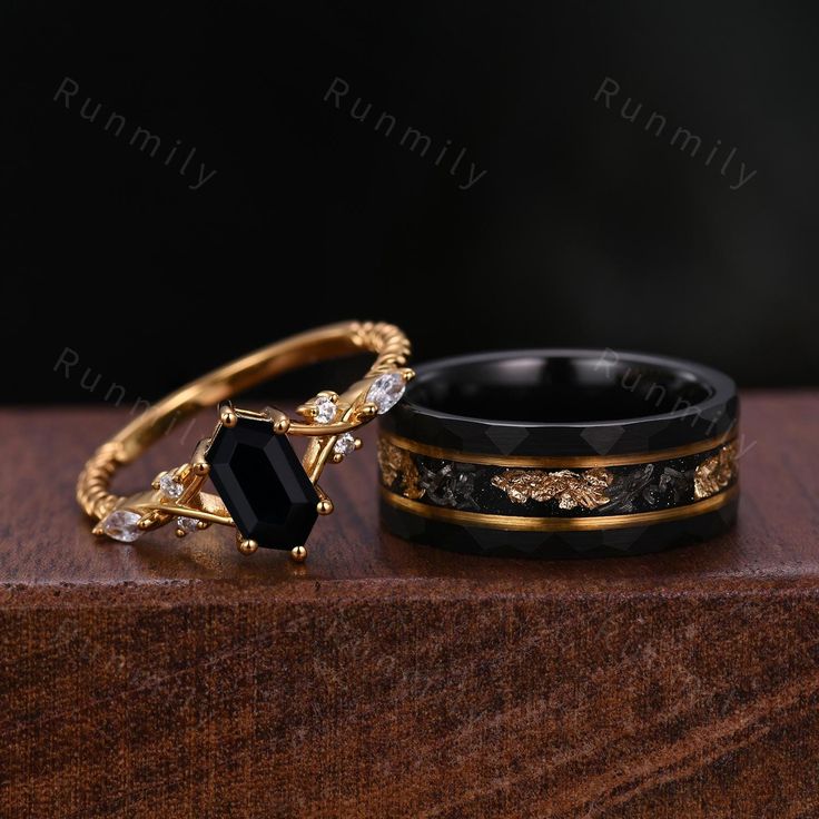 two gold rings with black onyxite and white diamonds sitting on top of each other