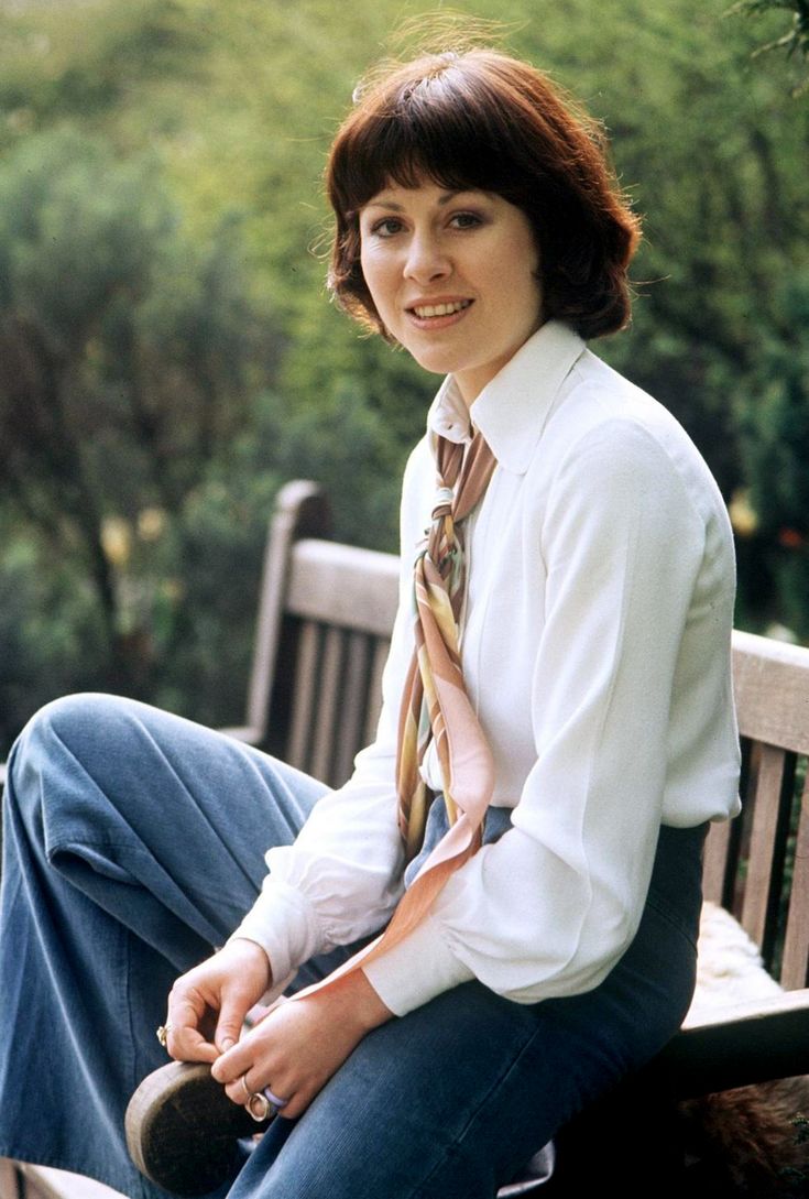 a woman sitting on a bench wearing a tie