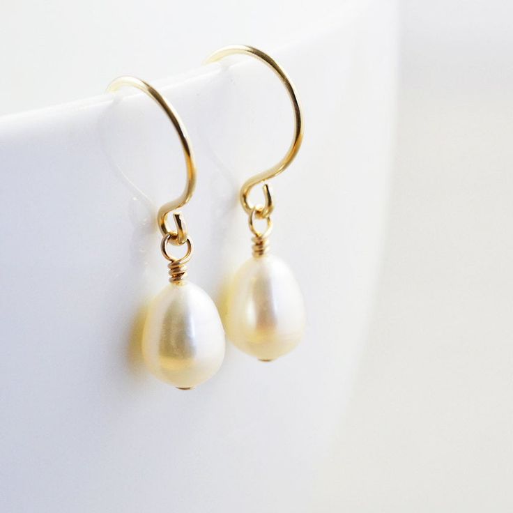 "White pearl earrings. Gold filled earrings featuring lustrous 7mm white freshwater teardrop shaped pearls handpicked to match as perfect as possible. They hang from handcrafted gold filled ear wires I created especially for these pearls. Perfect for everyday wear! Length from top of ear wire is slightly under 1\". Variations: Sterling silver Gold fill Rose gold fill Complimentary Gift Wrap! Not quite what you are looking for? Other earrings available: Studs: http://etsy.me/1zWKO9Q Earrings: htt Classic Pearl Teardrop Earrings, Classic Teardrop Earrings With Pearl Pendant, Classic Teardrop Earrings With Pearl Charm, Classic Teardrop Pearl Pendant Earrings, Classic Pearl Pendant Teardrop Earrings, Classic Pearl Teardrop Dangle Earrings, Everyday Teardrop Pearl Earrings, Classic Teardrop Pearl White Earrings, Delicate Pear-shaped Pearl Charm Earrings