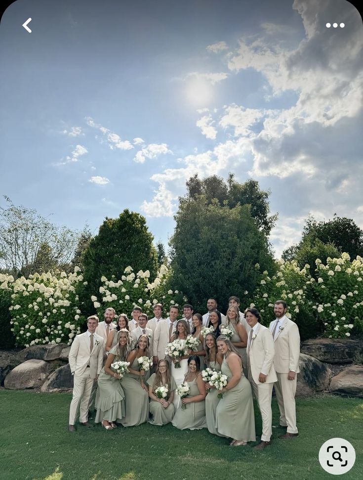 a group of people standing next to each other on top of a lush green field