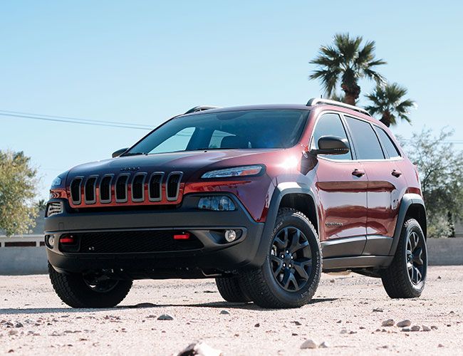 a red jeep is parked in the desert