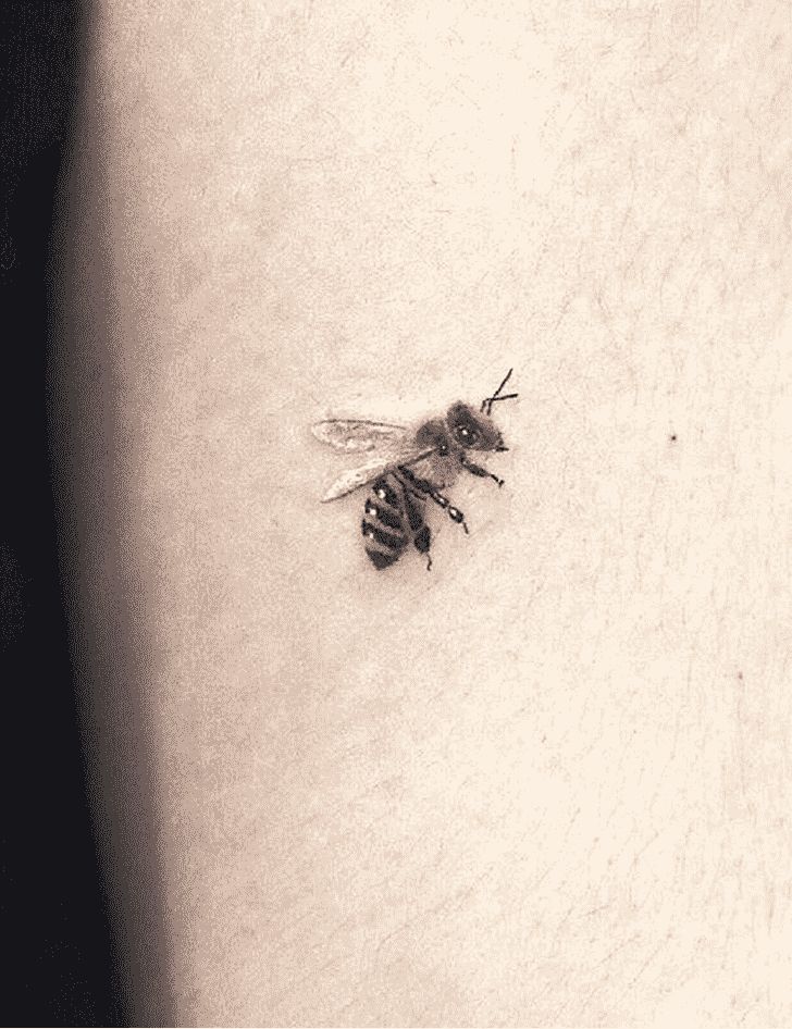 a black and white photo of a bee on the back of a woman's stomach