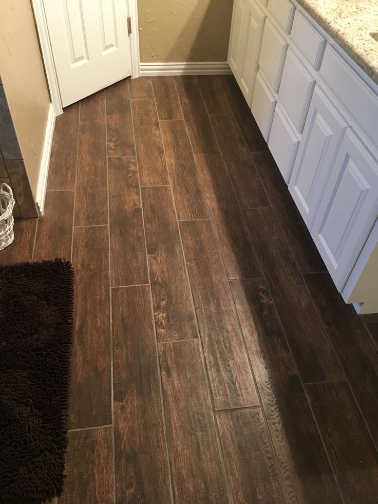 a bathroom with wood flooring and white cabinets