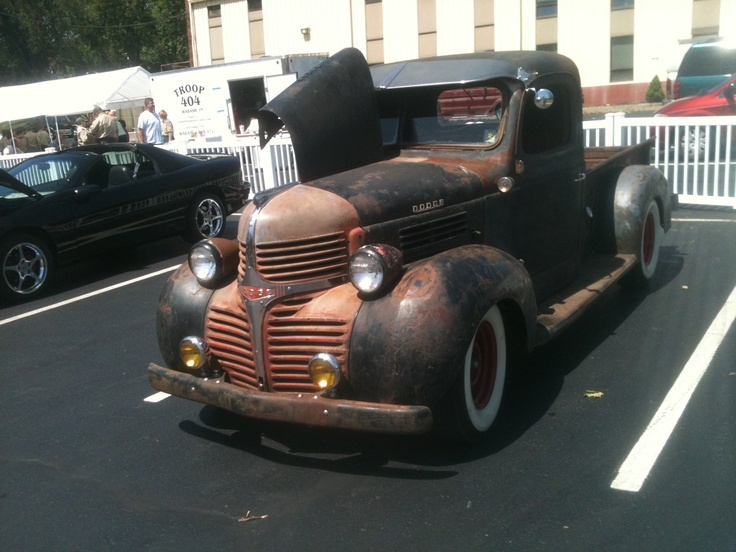 an old truck is parked in a parking lot