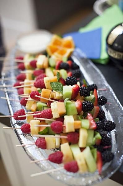 fruit skewers are lined up on a platter