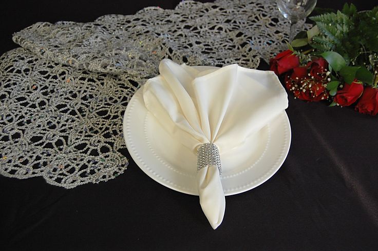 the table cloths are white and have lacy doily on them with red flowers in the background