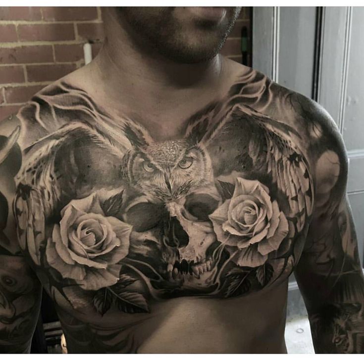 a man with an owl and roses tattoo on his chest is looking at the camera