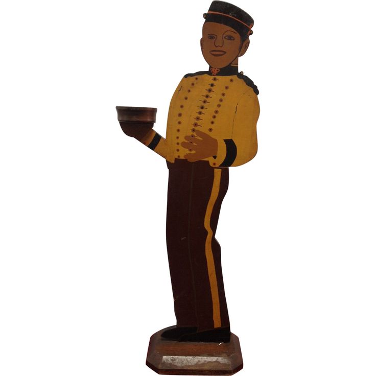 a statue of a man holding a cup and saucer in one hand, wearing a yellow uniform