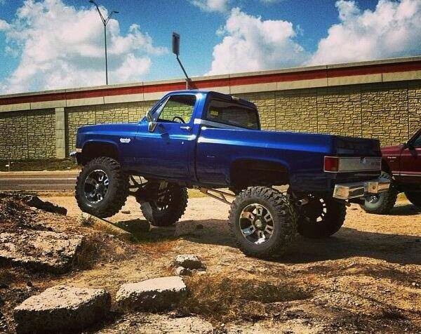 a blue pickup truck parked in front of a building