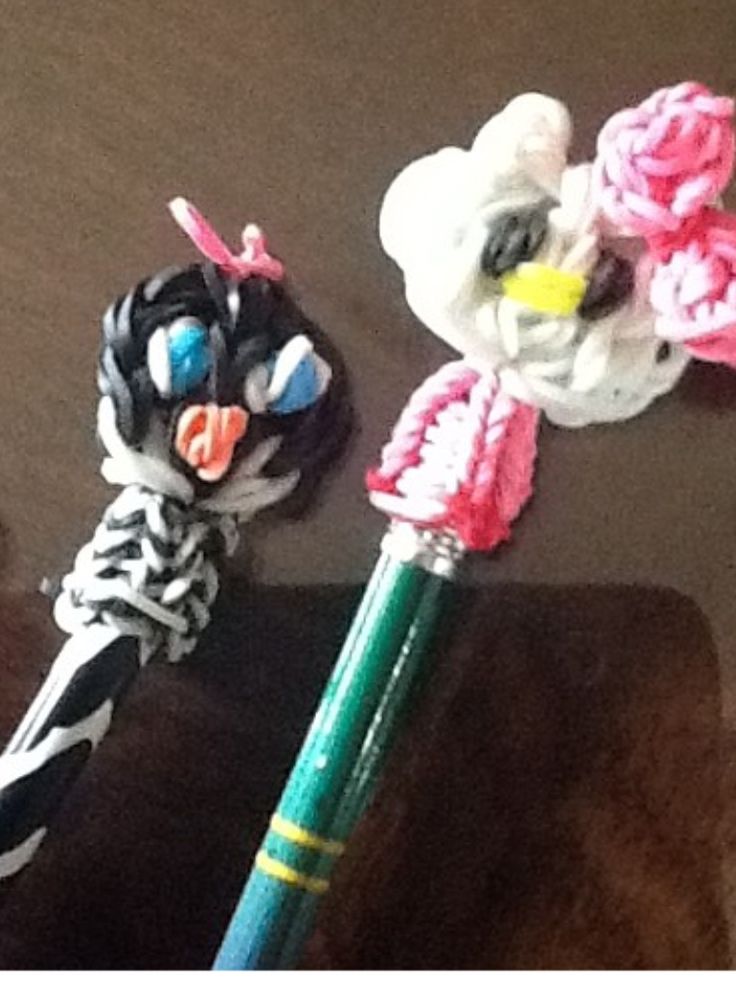 two pens with different designs on them sitting next to each other in front of a stuffed animal