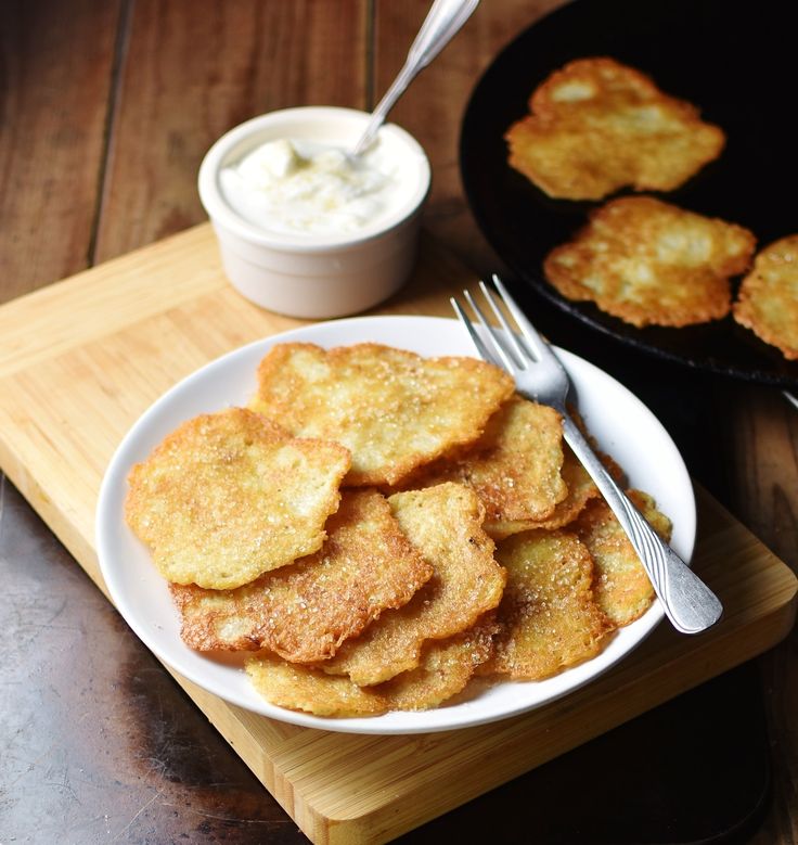 some fried food is on a plate with a fork and knife next to it, along with a bowl of ranch dressing