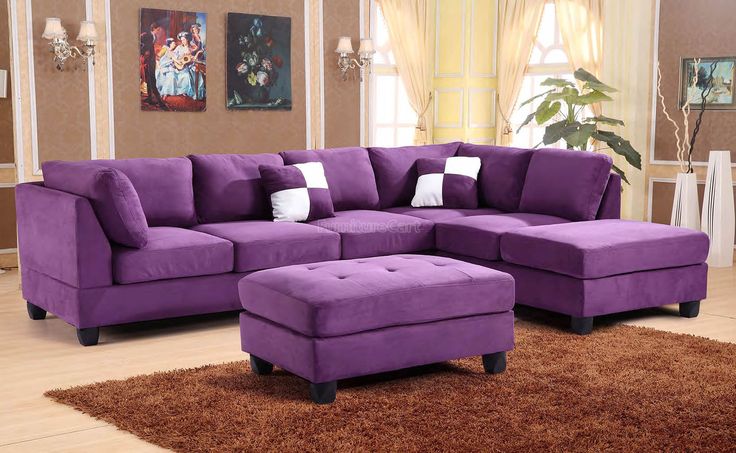 a living room with a purple couch and ottoman