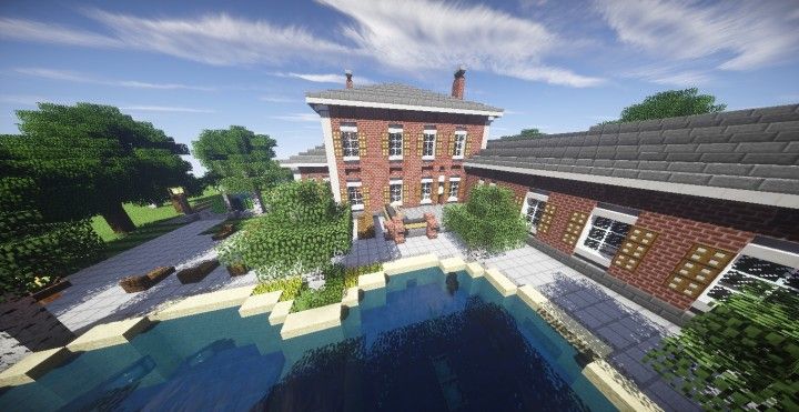 a large brick building with a pool in front of it and trees around the pond