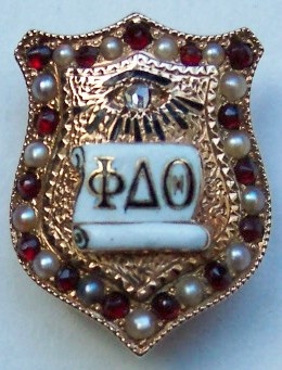 a brooch with the word pao written in white and surrounded by garnets