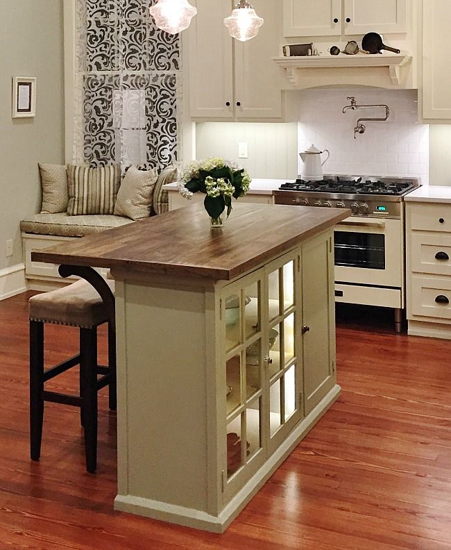 a kitchen island with stools in front of it and an oven on the other side