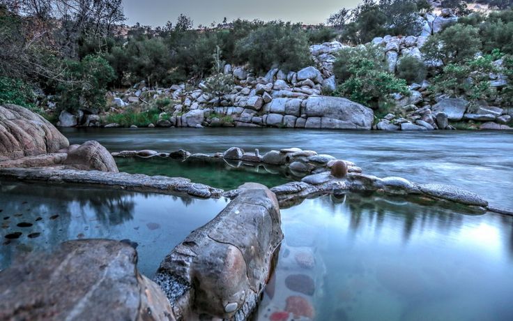 a river with rocks and water surrounded by trees