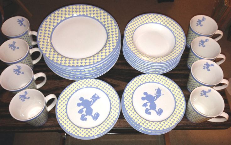 a table topped with lots of blue and white plates covered in mickey mouse silhouettes