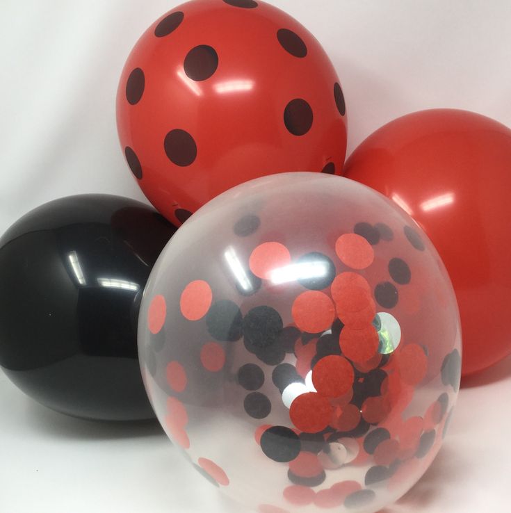 three balloons with black and red polka dots on them are sitting next to each other