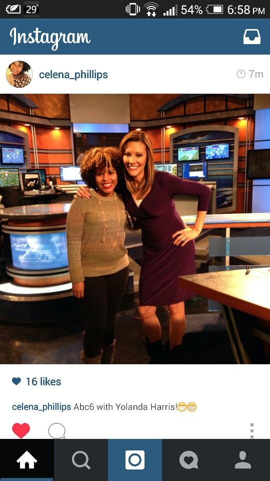 two women standing next to each other in front of television screens