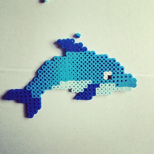 a blue and white dolphin made out of perler beads