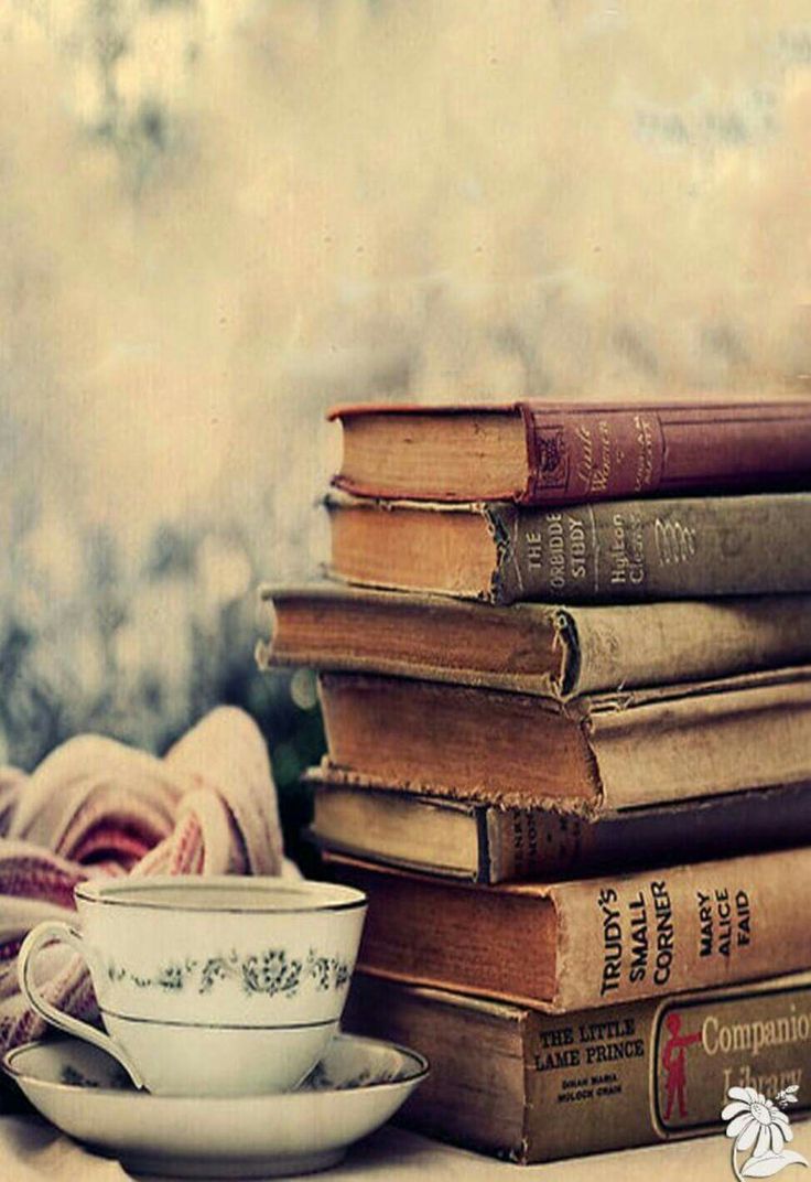 a stack of books sitting next to a cup and saucer