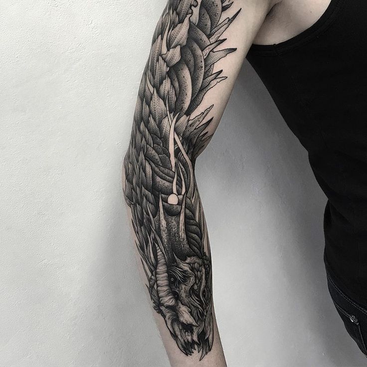 a man with a dragon tattoo on his arm