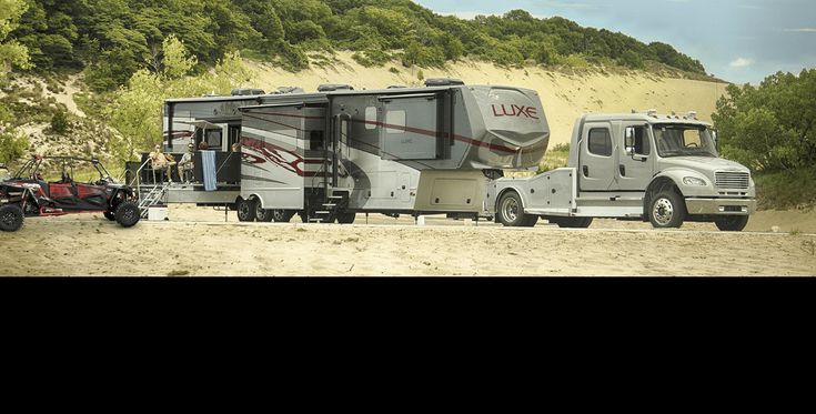 a truck towing a camper on the road