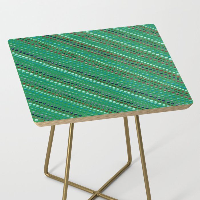 a small green table with gold legs and a pattern on the top that matches it