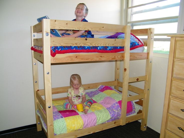 two children sitting on top of bunk beds