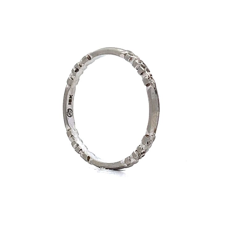 This original Art Deco wedding band, crafted in 18 karat white gold, embodies the elegance of its era with authenticity and grace. The band, a slender 2 mm in width, features four engraved orange blossom stations that capture the intricate beauty of nature. Milgrain detailing along the edges adds a layer of texture, enhancing the design's depth and sophistication. This piece, true to its time, offers a refined and understated charm, making it a perfect complement to an engagement ring or a delic Silver Platinum Bands, Timeless Silver Platinum Stackable Rings, Timeless Silver Stackable Platinum Rings, Timeless White Gold Bands With Single Cut Diamonds, Silver Platinum Stackable Rings In Fine Jewelry, Classic Silver Platinum Eternity Band, Heirloom White Gold Band With Polished Finish, Classic Silver Bands With Diamond Cut, Classic Platinum Silver Eternity Band