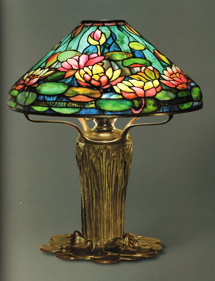 a lamp with flowers on it sitting on top of a table