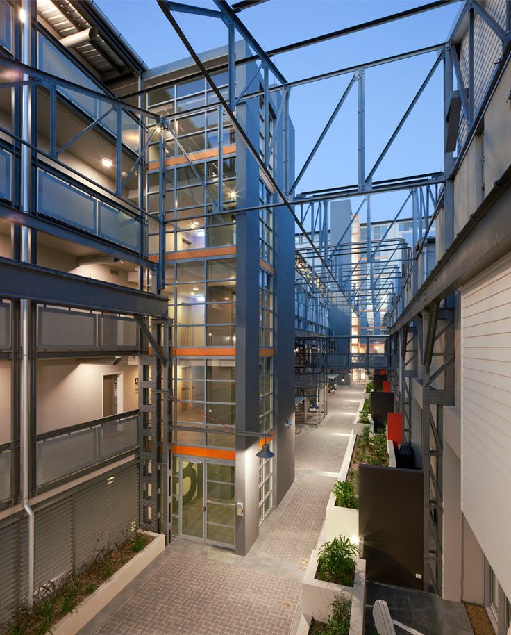 the inside of an office building with glass walls and metal railings on both sides