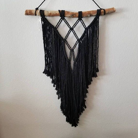 a black macrame hanging on a wall