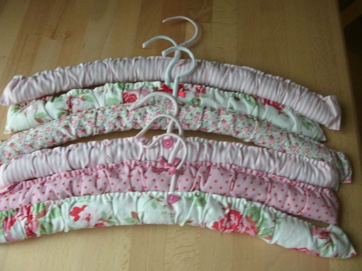 five pieces of fabric hang on a wooden floor with white strings attached to them and pink flowers