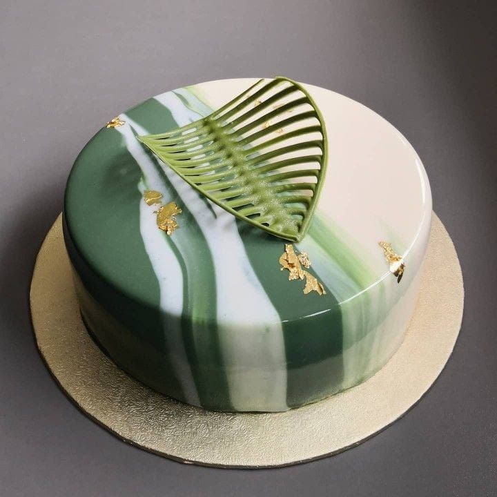 a green and white striped cake with a comb on it's top sitting on a plate