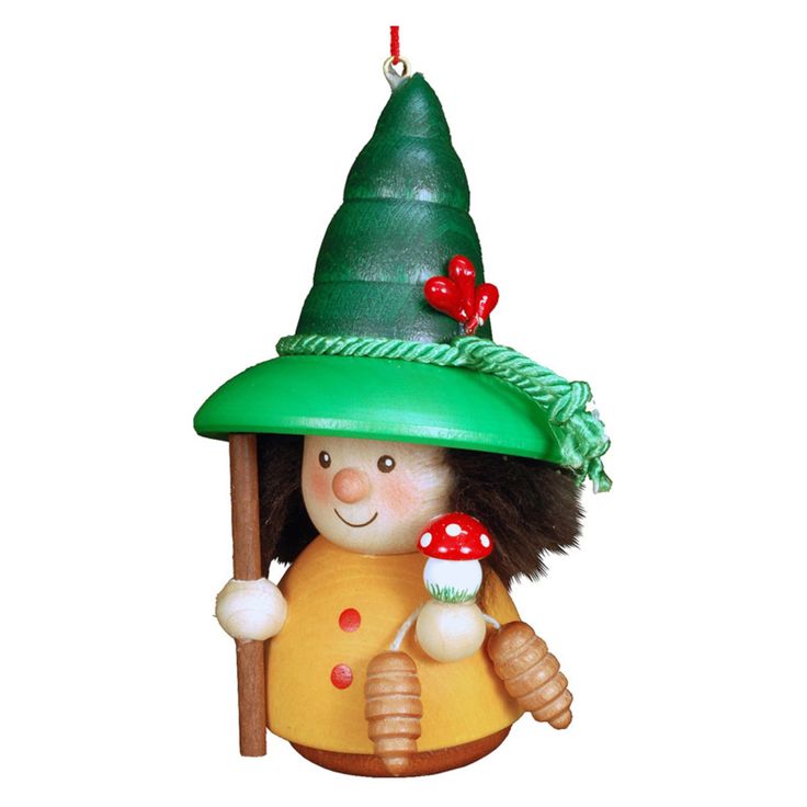 a ceramic ornament with a green hat on it's head holding a cupcake