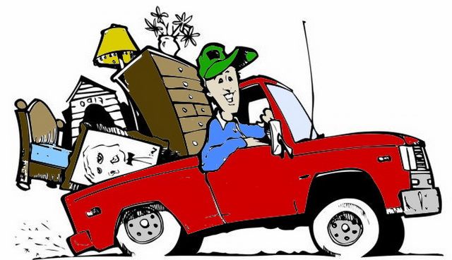 a man driving a red pick up truck filled with furniture and boxes on the back