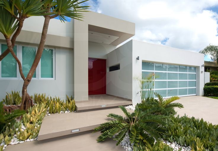 a house with plants and trees in front of it