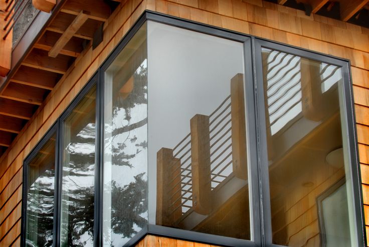 a wooden building with glass windows and railings