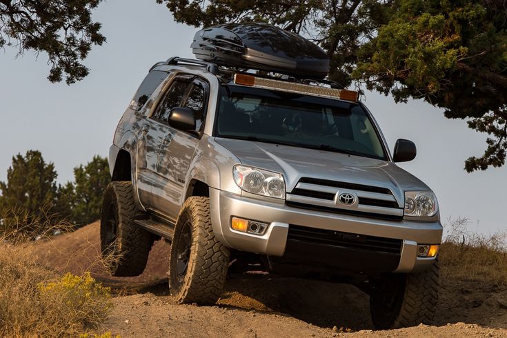 a silver suv driving down a dirt road